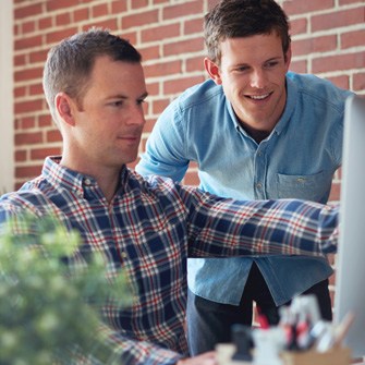 Two men gathered around a computer display.