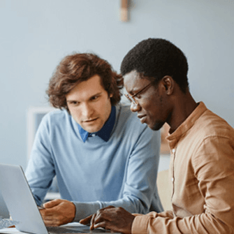 Two people working together in front of a laptop