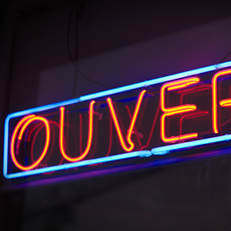 A neon sign reading "OUVERT".