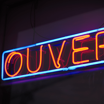 A neon sign reading "OUVERT".