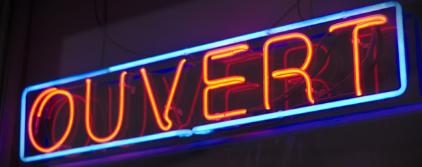 A neon sign reading "OUVERT".