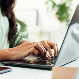 A woman typing on her laptop
