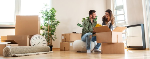 A woman and man unpacking boxes in a new house.