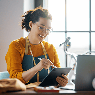 A young woman with glasses working on her tablet