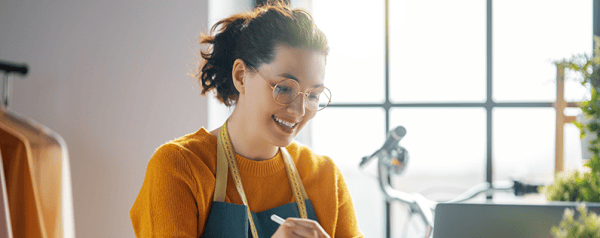 A young woman with glasses working on her tablet